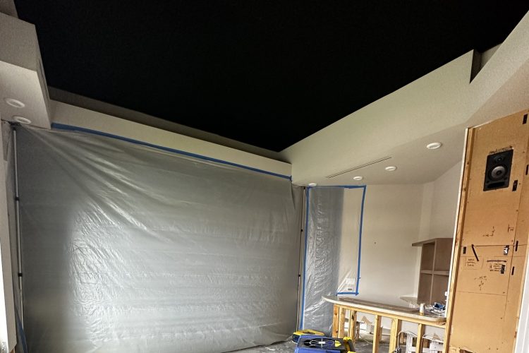 Room with plastic containment sheeting, equipment and opened lower wall sections